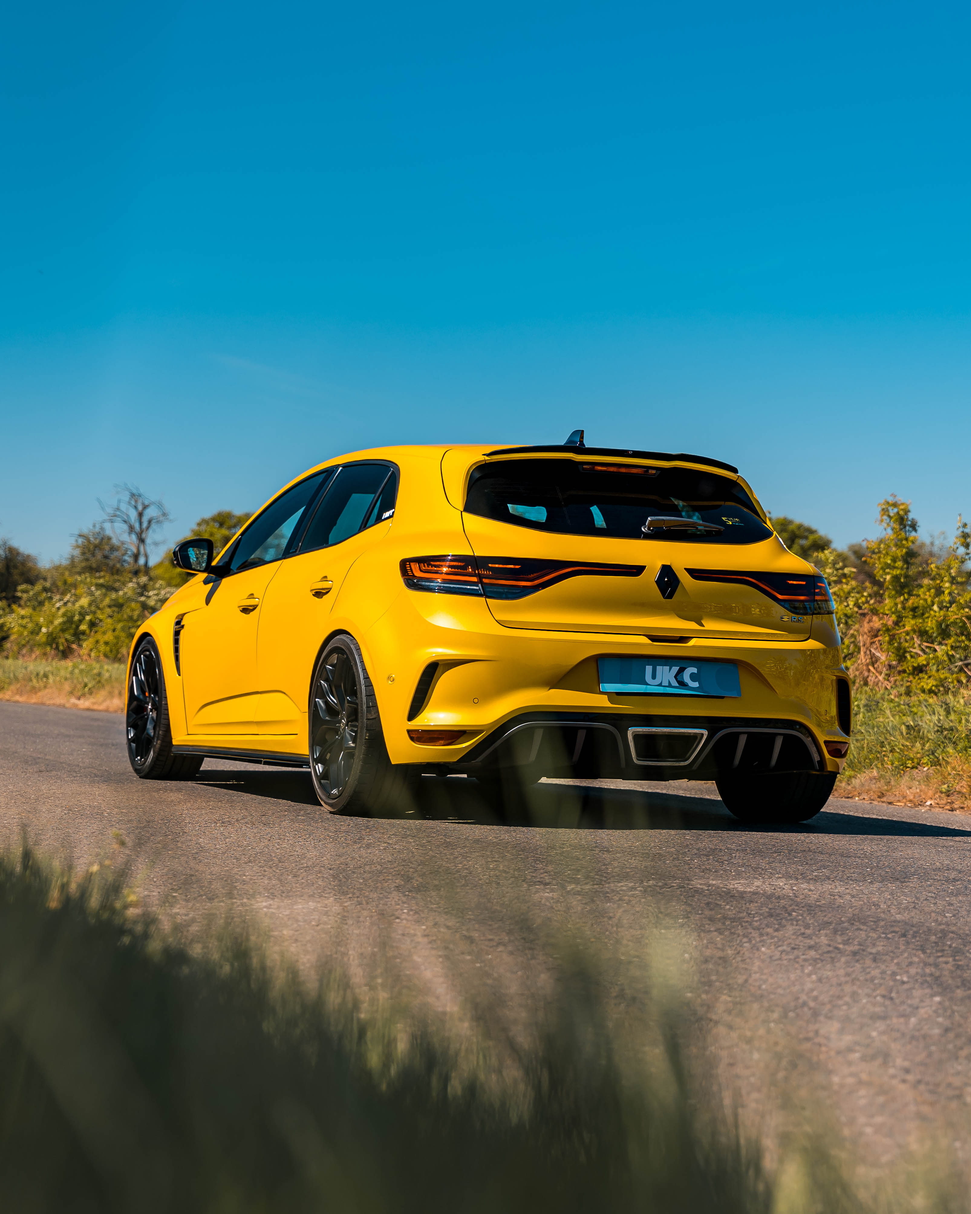 Yellow Renault Megane RS parked up 45 degree angle on road